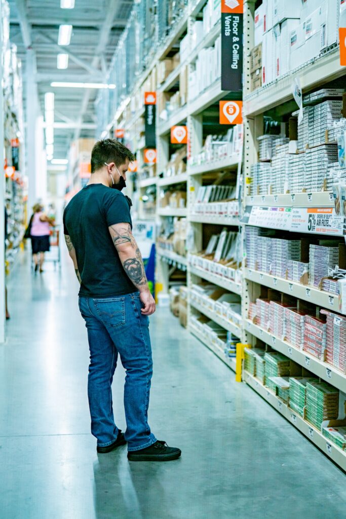 a man standing in a store aisle looking at items
